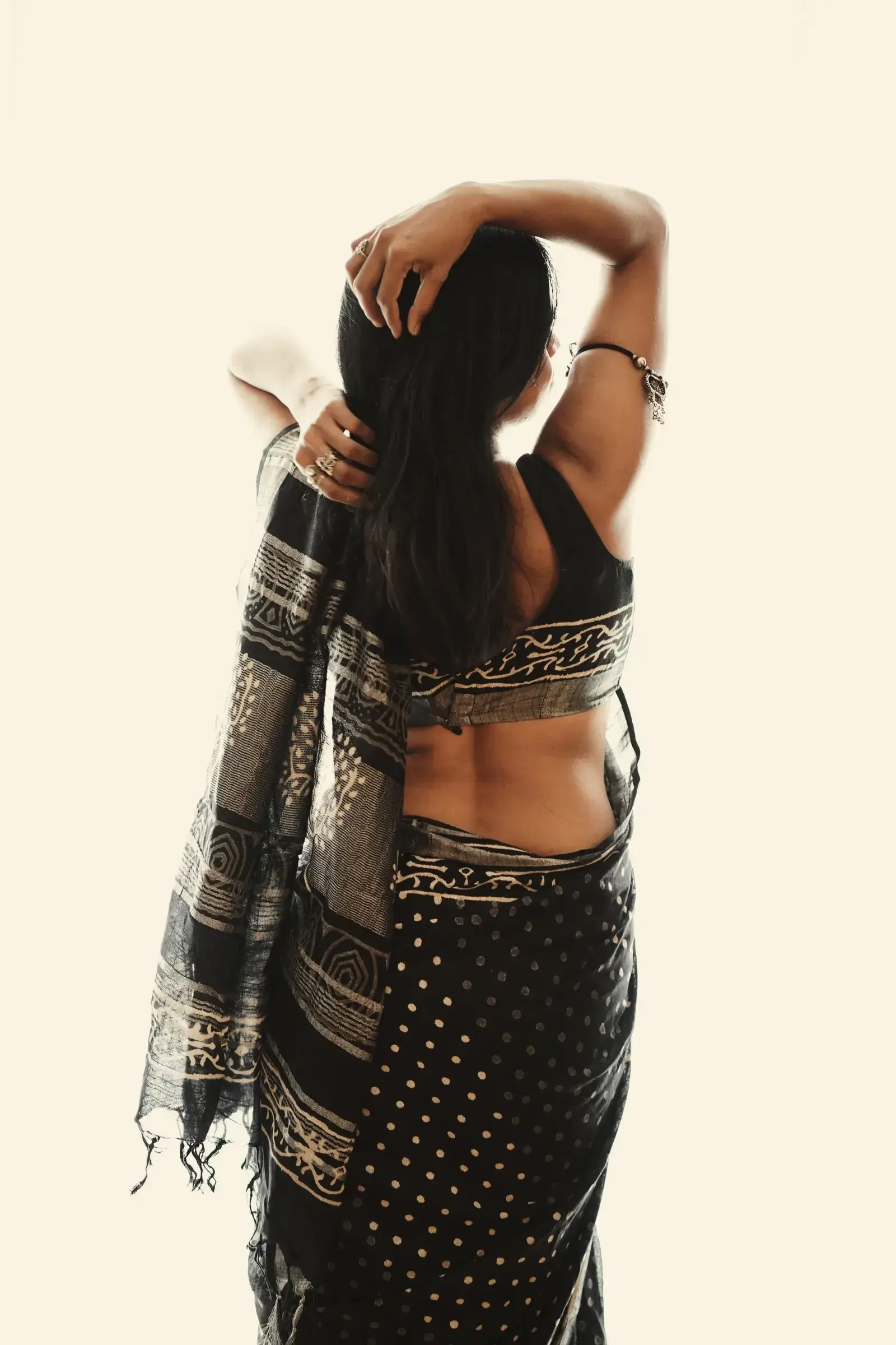 The black jamdani saree seen from behind, pallu hanging over the shoulder